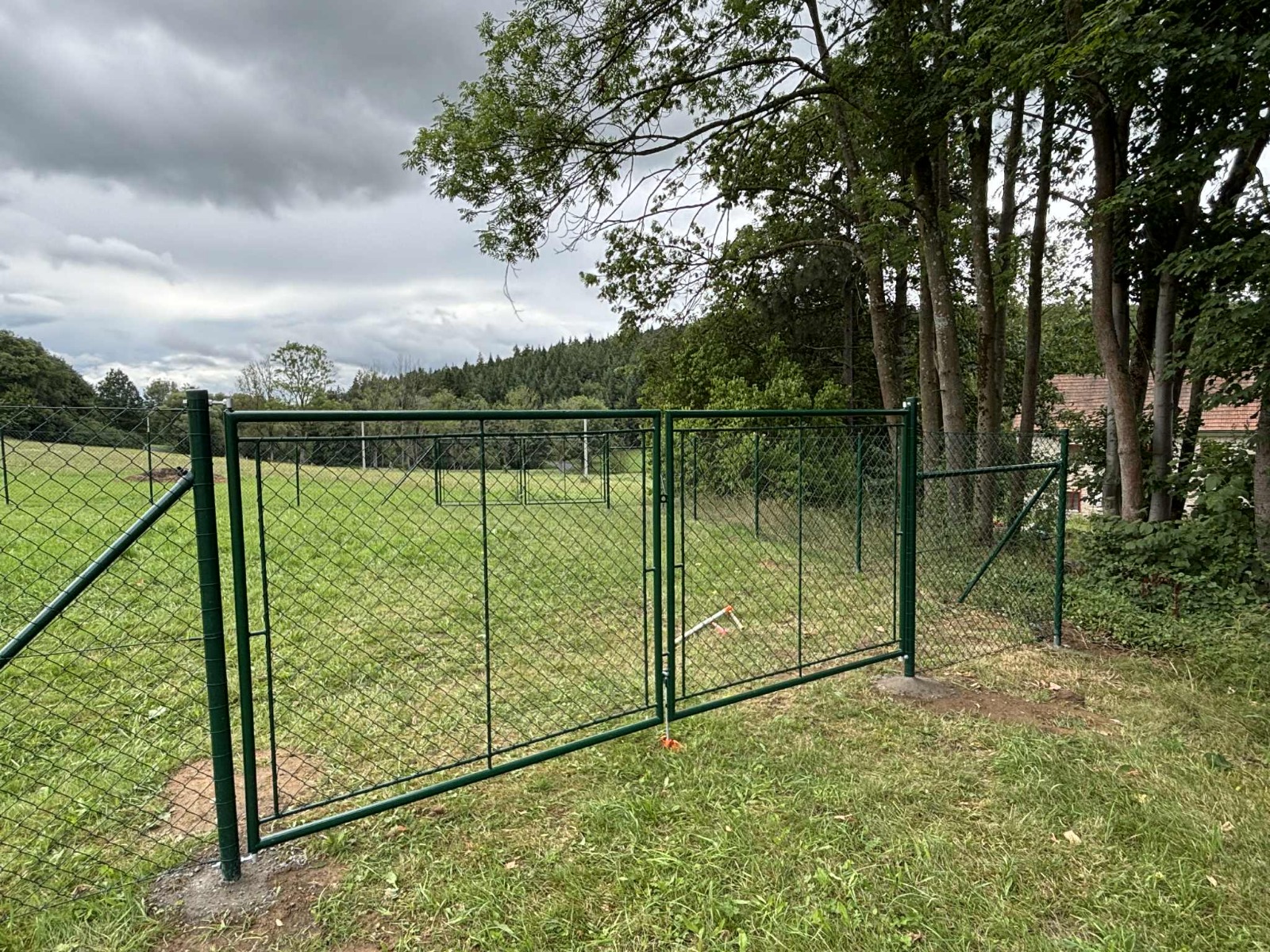 Zelená dvoukřídlá brána s pletivovým oplocením